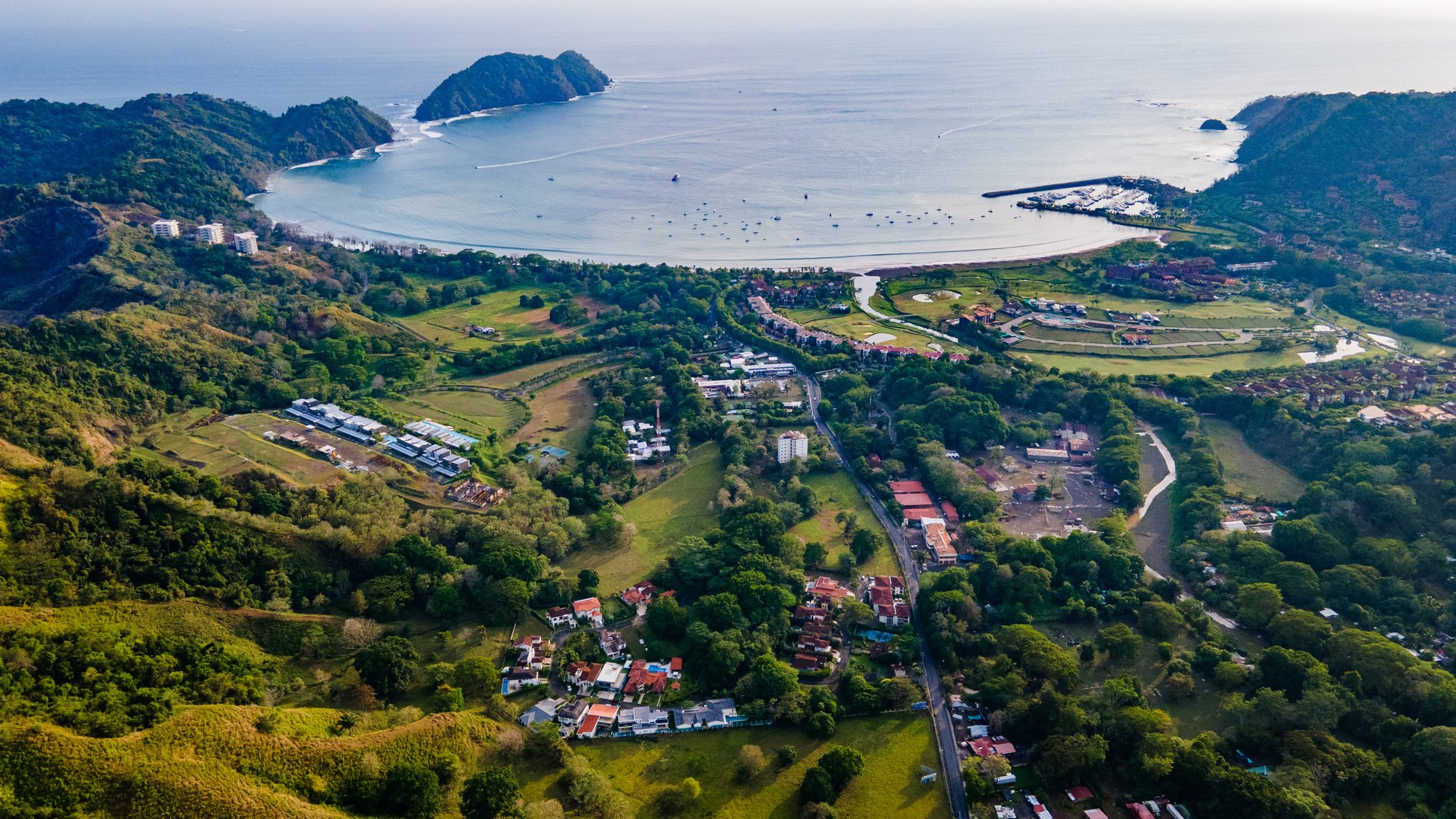 Bahía y valle con pueblo, vista aérea