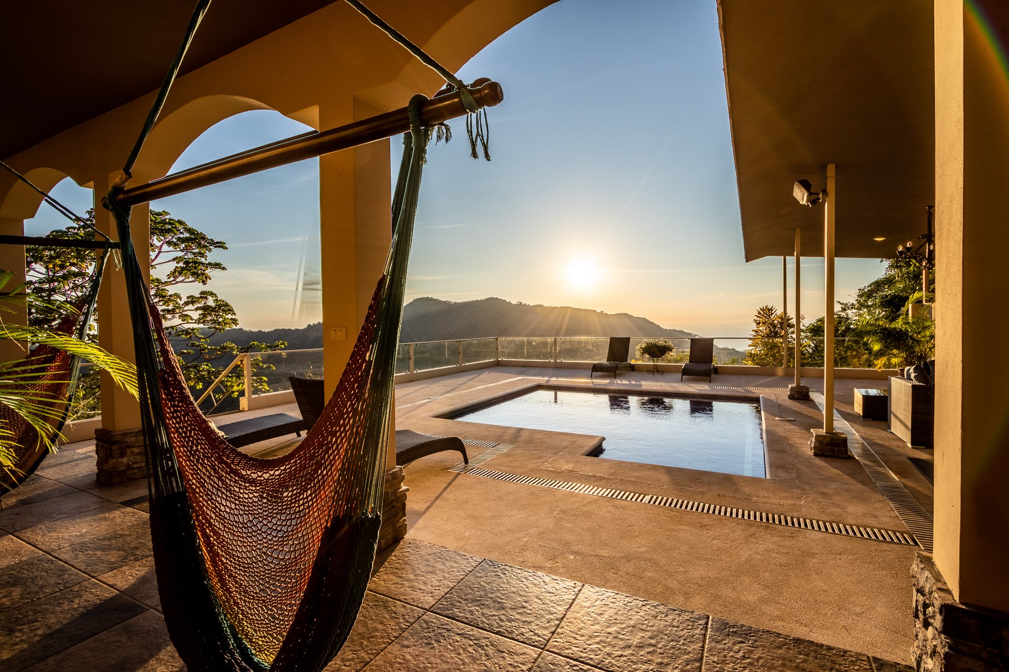 Terraza con hamaca y piscina al atardecer